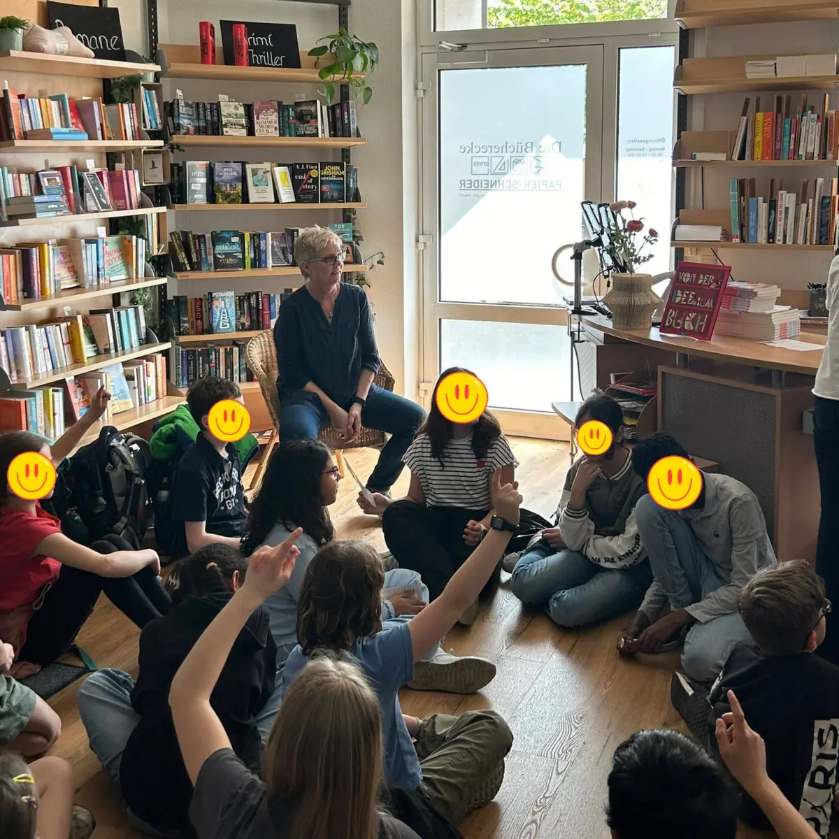 Vorlesestunde für Kinder in der Buchabteilung von Papier-Schneider